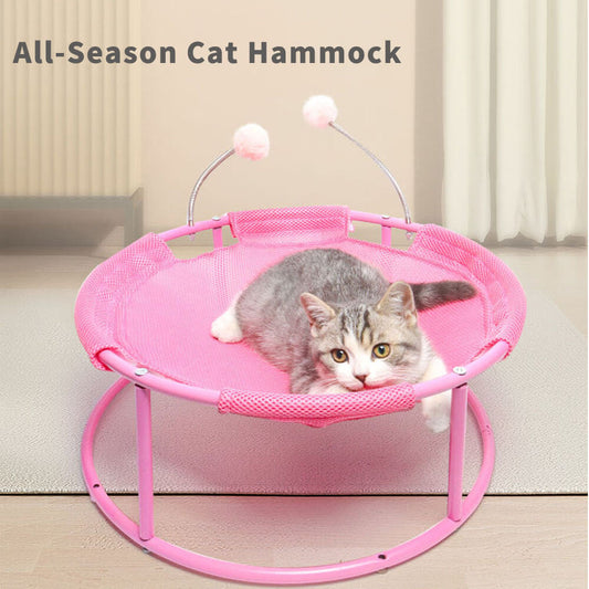 Pink all-season cat hammock bed with a cute tabby cat lying on it, featuring breathable mesh fabric and interactive spring pom-pom toys for indoor cats.