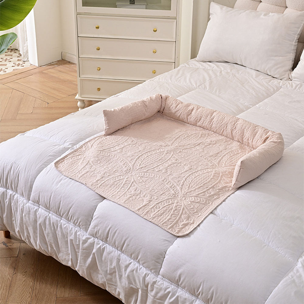 Beige semi-enclosed pet bed mat with quilted texture and raised neck support edges, placed on a white bed to show versatile use as a furniture protector and cozy pet nest, ideal for dogs and cats, all-season design