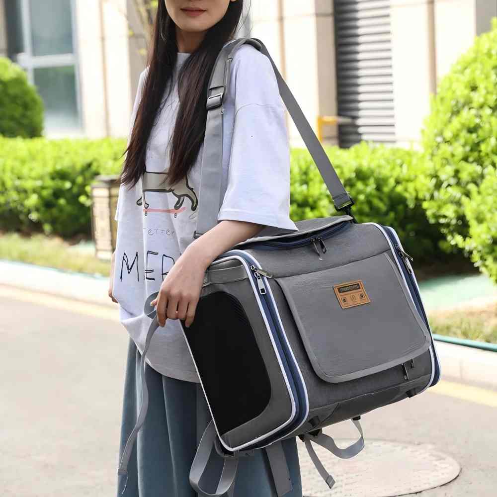 A grey convertible pet carrier worn as a shoulder bag, designed to seamlessly switch between bike basket, backpack, and hand-held modes, eliminating the need for multiple bags when moving from cycling to hiking.