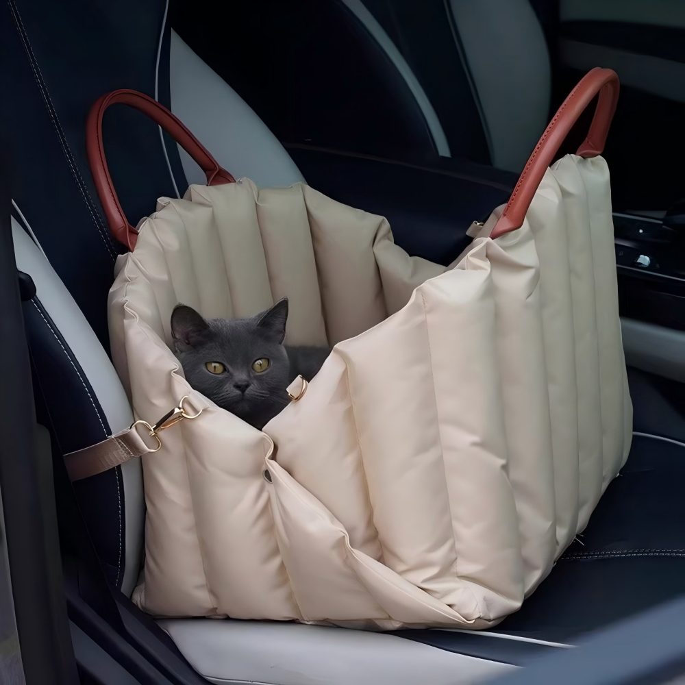 Grey cat nestled in a spacious pet carrier placed on a car seat, compatible with both cats and small dogs for safe car travel