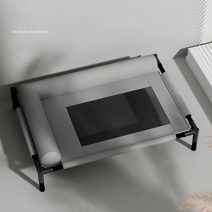 Elevated pet cot bed with semi-enclosed bolster pillow, breathable mesh center, and sturdy black metal frame, shown in a minimalist indoor setting for dogs and cats, all-season use.
