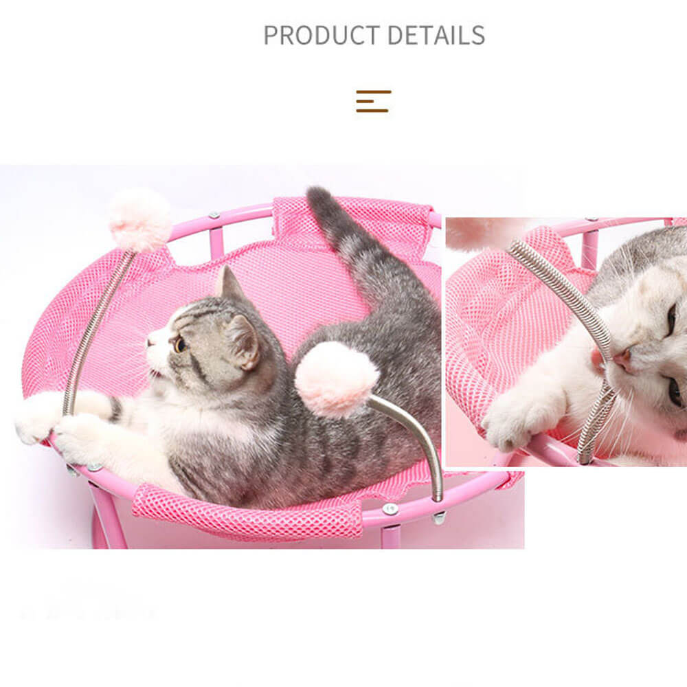 Pink elevated cat hammock with interactive spring pom-pom toys, showing a tabby cat playing and resting, highlighting the engaging design for indoor cats.
