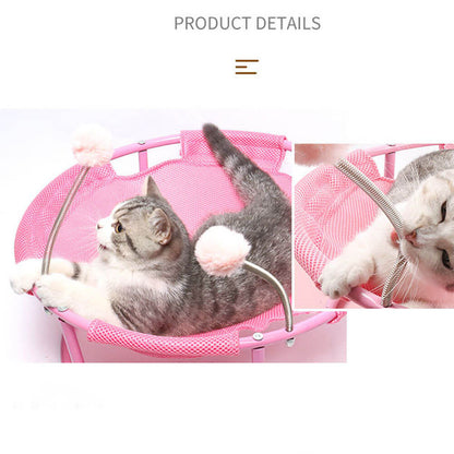 Pink elevated cat hammock with interactive spring pom-pom toys, showing a tabby cat playing and resting, highlighting the engaging design for indoor cats.
