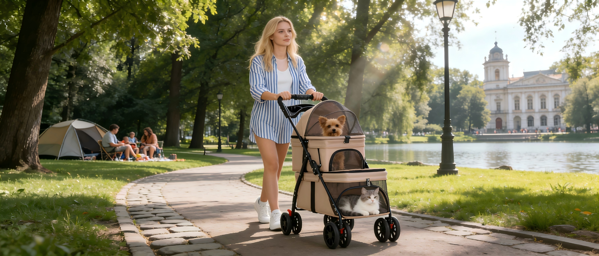 A woman pushing a beige Misstiy double-decker pet stroller (with breathable mesh compartments) along a sunlit park path: a Yorkshire Terrier rests in the upper section, while a cat lounges in the lower section – the background shows a casual camping spot & lake, highlighting this stroller’s perfect fit for multi-pet outdoor trips and leisure adventures.