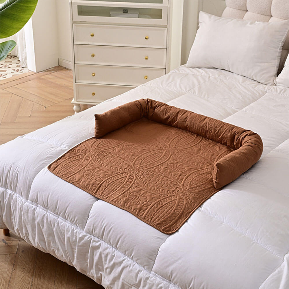 Brown semi-enclosed pet mat placed on a white bed, demonstrating versatile use as a bed mat, sofa protector, or car seat cover, with a cozy raised edge for neck support and decor-friendly design
