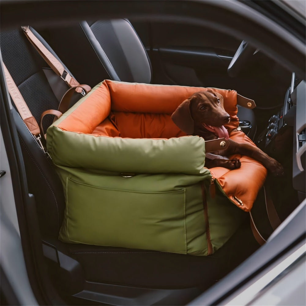  happy brown dog sitting securely in an olive green and orange multifunctional pet car seat carrier installed in a car, emphasizing safe travel, crash protection, and cozy comfort for pets during drives.