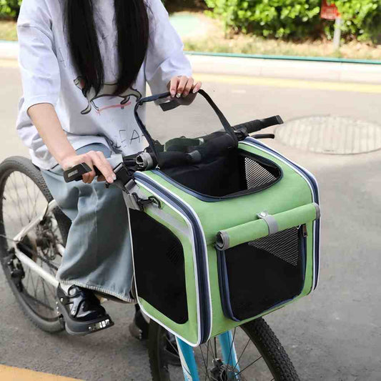 A green multi-functional pet bike basket carrier securely mounted on a bicycle handlebar, featuring mesh ventilation to keep pets cool and a stable fixed design that prevents falls during bumpy rides, reducing pet anxiety and ensuring safety.