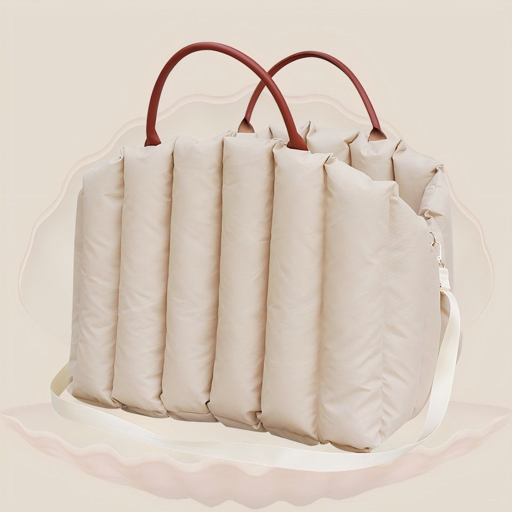 Beige padded pet carrier with leather handles and detachable shoulder strap, blending style and portability for pet owners